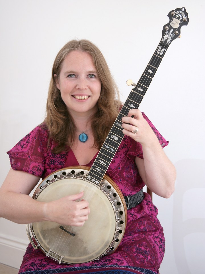 Danielle Saxon Reeves seated with her banjo